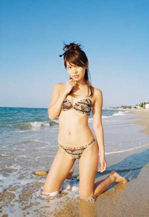 海辺でポーズをとる若きグラビアモデルの夏の日差し