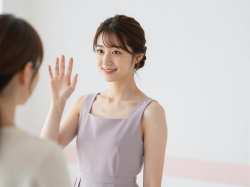 笑顔で手を振る女性のパステルカラードレスポートレート