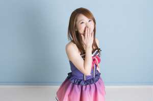 笑顔で手を口元に持つ女性ポートレート