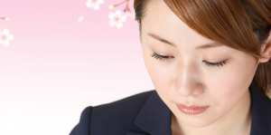 桜の背景で静かに見つめるビジネス女性のポートレート