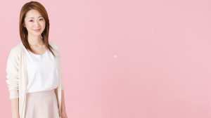 ピンク背景の微笑む女性ポートレート写真