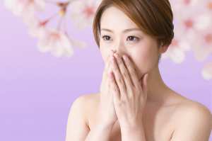 桜の背景で手を合わせた美しい女性のポートレート