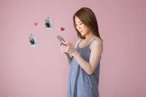 ピンクの壁に写真が飾られた女性のポートレート