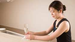 ホテルのバーでシャンパンを拭う女性