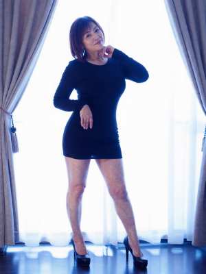 窓辺でポーズをとる黒いドレスの女性