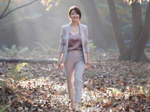 秋の森を歩くスタイリッシュな女性のポートレート