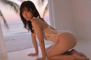 夕暮れ時のビーチでポーズをとる美女のポートレート