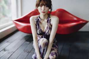 窓辺でポーズをとる若き女性のポートレート