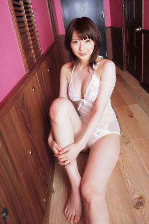 ピンクの壁と木製の壁に囲まれた、白いセクシーなワンピースを着た女性のポートレート