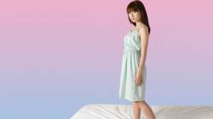 ピンクとブルーのグラデーション背景に立つ若い女性のポートレート