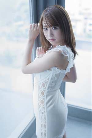 窓辺でポーズをとる白いドレスの女性ポートレート