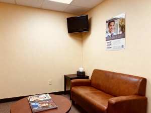 ベージュの壁と茶色の革張りのソファが置かれたモダンな待合室。