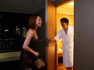 夜のホテルの部屋で、モダンなホテルの部屋のドアに立っているカップル。