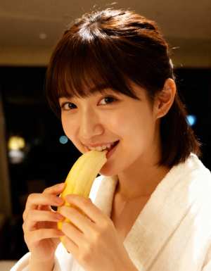 バナナを食べる若い女性をクローズアップ カメラ アングルから写実的に撮影したもの。