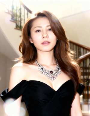 黒いオフショルダー ドレスとステートメント ネックレスを身に着けた、ウェーブのかかっ...。