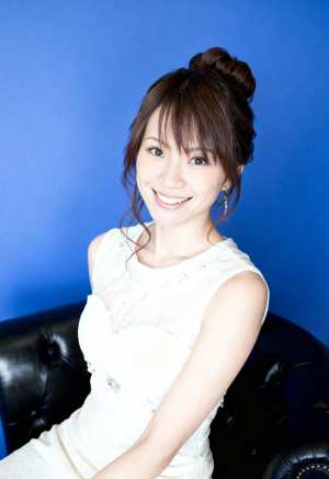 明るい青色の背景に黒い革張りのソファに座っている若い女性のポートレート。