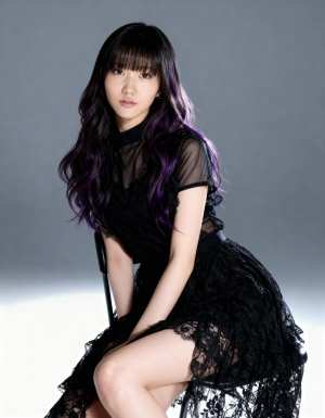 ウェーブのかかった長い黒髪と紫のハイライトを持つ若い女性が、黒いレースのドレスを着て...。