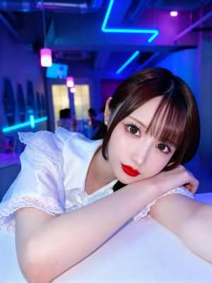 半袖の白いブラウスを着て赤い口紅をつけた若い女性が真剣な表情でテーブルに座っている様...。