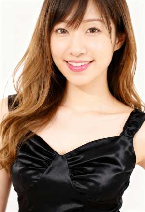 ウェーブのかかった茶色の長い髪と白い肌を持ち、カメラに向かって直接微笑む若いアジア人...。