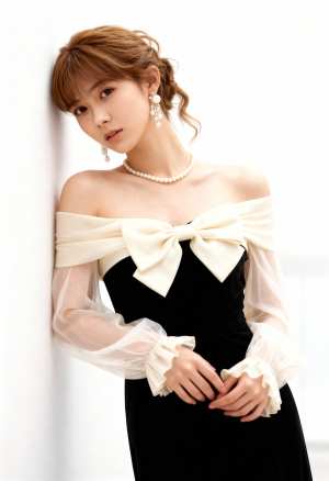 薄手の袖と大きなリボンが付いたフォーマル ドレスを着て、真っ白な壁に向かってポーズを...。