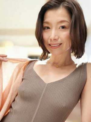 カメラに向かって微笑む、短く濃い茶色の髪を持つ中年のアジア人女性のポートレート。