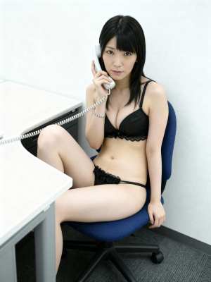 オフィス環境で青いオフィスチェアに座っている若い女性をフィーチャーした、横からの写実...。