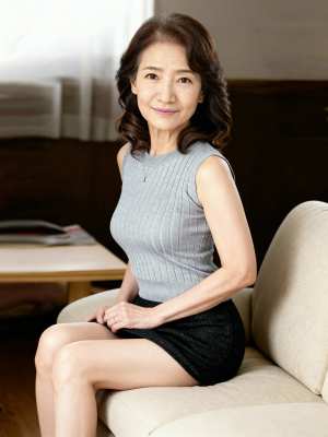 モダンなリビングルームのベージュのソファに座っている中年のアジア人女性のポートレート。