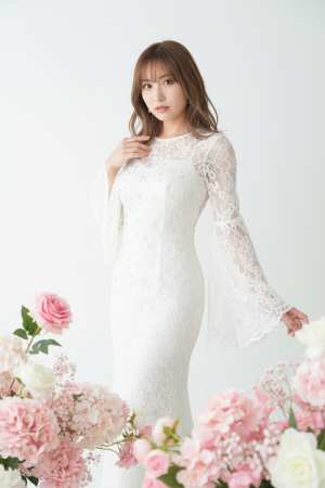 ピンクと白の花に囲まれた白いレースのウェディング ドレスを着た若い女性を正面カメラ ...。