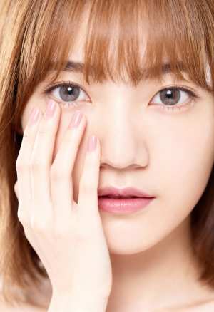右手で顔に触れながら、思慮深い表情をしたアジア系の若い女性の接写。