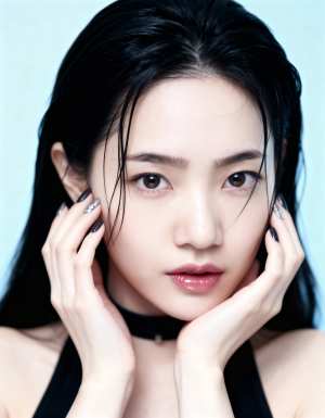 長い黒髪の若い女性が顎に手を当ててポーズをとるクローズアップのポートレート。