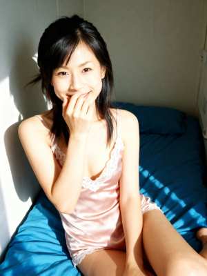 レースのトリムが付いたピンクのサテンのナイトガウンを着て、居心地の良い寝室のベッドに...。