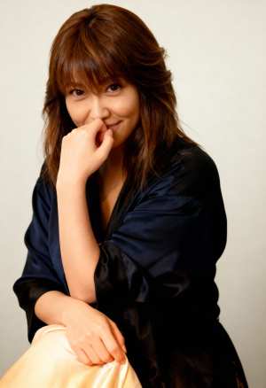 長い茶色の髪と思慮深い表情を持ち、あごを手に乗せてポーズをとっている若い女性を、ポー...。