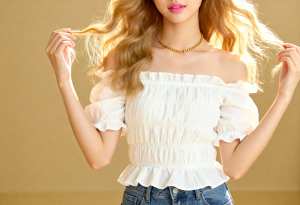 白いオフショルダーのトップスとブルー ジーンズを着た、ウェーブのかかったブロンドの長...。