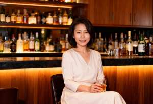 A portrait of a woman sitting at a bar in ...。
