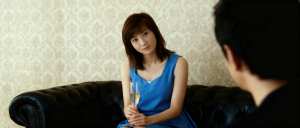 シャンパングラスを手に黒い革張りのソファに座り、注意深く座っている男性を見つめている...。