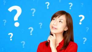 赤いシャツを着た長い茶色の髪の若いアジア人女性が、画像の中央に顎を手に乗せて座り、思...。