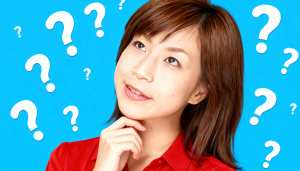 明るい青色の背景に疑問符で囲まれた、思慮深い表情を持つ若いアジア人女性のポートレート。