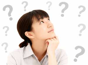 画像の中央には思慮深い表情を浮かべたアジア系の若い女性が、顎を手に乗せて座り、頭上に...。