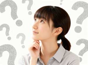 白い背景に疑問符で囲まれた、思慮深い表情をした若いアジア人女性を横顔カメラのアングル...。