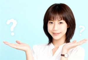 ショートボブのヘアカットをした若いアジア人女性が、両手で何かを差し出しながら視聴者に...。