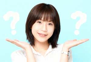 短くストレートなダークブラウンのボブヘアカットと白い肌を持ち、カメラに向かって微笑む...。