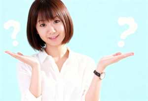 パステルブルーの背景に、白いブラウスを着たショートボブのヘアカットの若いアジア人女性...。