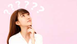 長い茶色の髪と前髪を持ち、白いブラウスを着た若い女性が画像の中央に位置し、無地のピン...。