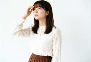 白いレースのブラウスと茶色のスカートを着た、思慮深い表情の若い女性を横顔カメラのアン...。