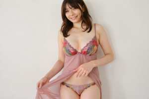 真っ白な壁を背景にフェミニンなランジェリーを着てポーズをとる若い女性を、正面カメラの...。