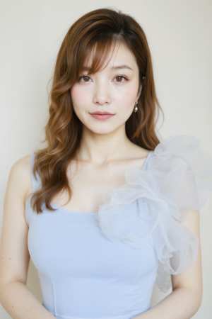 肩にチュールのフリルが付いたライトブルーのノースリーブトップを着た、ウェーブのかかっ...。