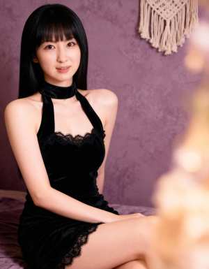 レースのトリムが付いた黒いベルベットのドレスを着て、紫の壁に向かってリラックスしたポ...。