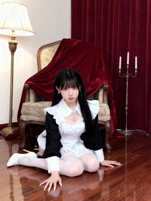 ワインレッドのベルベットの椅子と背の高い燭台を背景にした豪華な部屋の木の床にしゃがむ...。