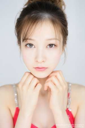 顔の前で手を組んでポーズをとる、中性的な表情の若い女性をクローズアップ カメラ アン...。