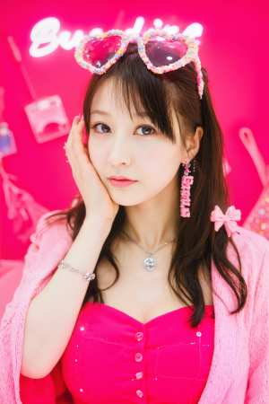 ピンクのアクセサリーを身に着けた若い女性と、「バドワイザー」と書かれたネオンサインの...。